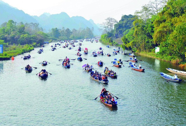 Rất nhiều du khách đang chèo thuyền vãn cảnh và vào động lễ Phật